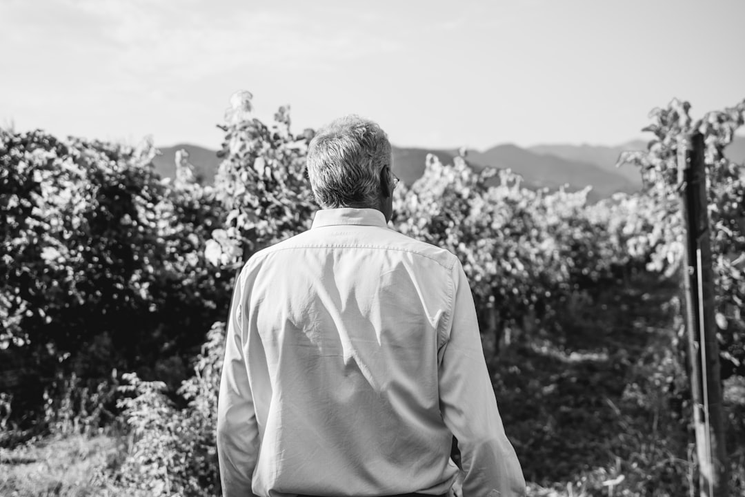 a-man-standing-in-front-of-a-vineyard-pzy-flelsku